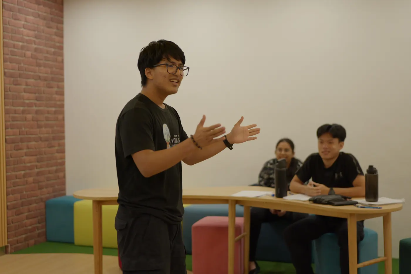 Secondary student delivering a TED-style talk to seated peers